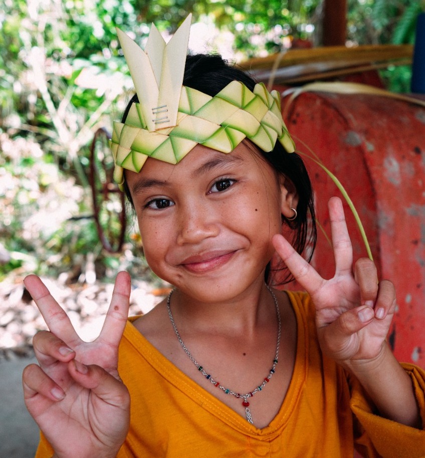 Sekolah Adat Anri Arai Atei student wearing a beautiful Dayak cultural headpiece.