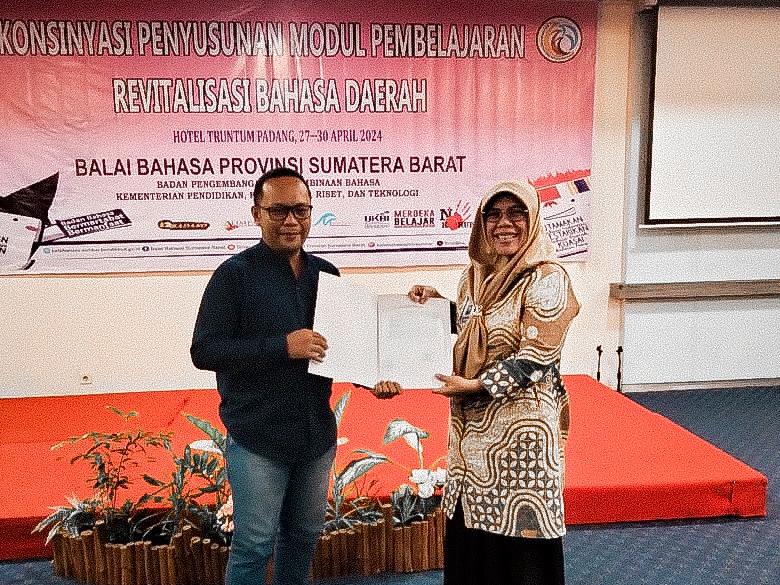 Suku Mentawai Chairman being presented with the Mentawai mythology publication by the West Sumatran Language Department.